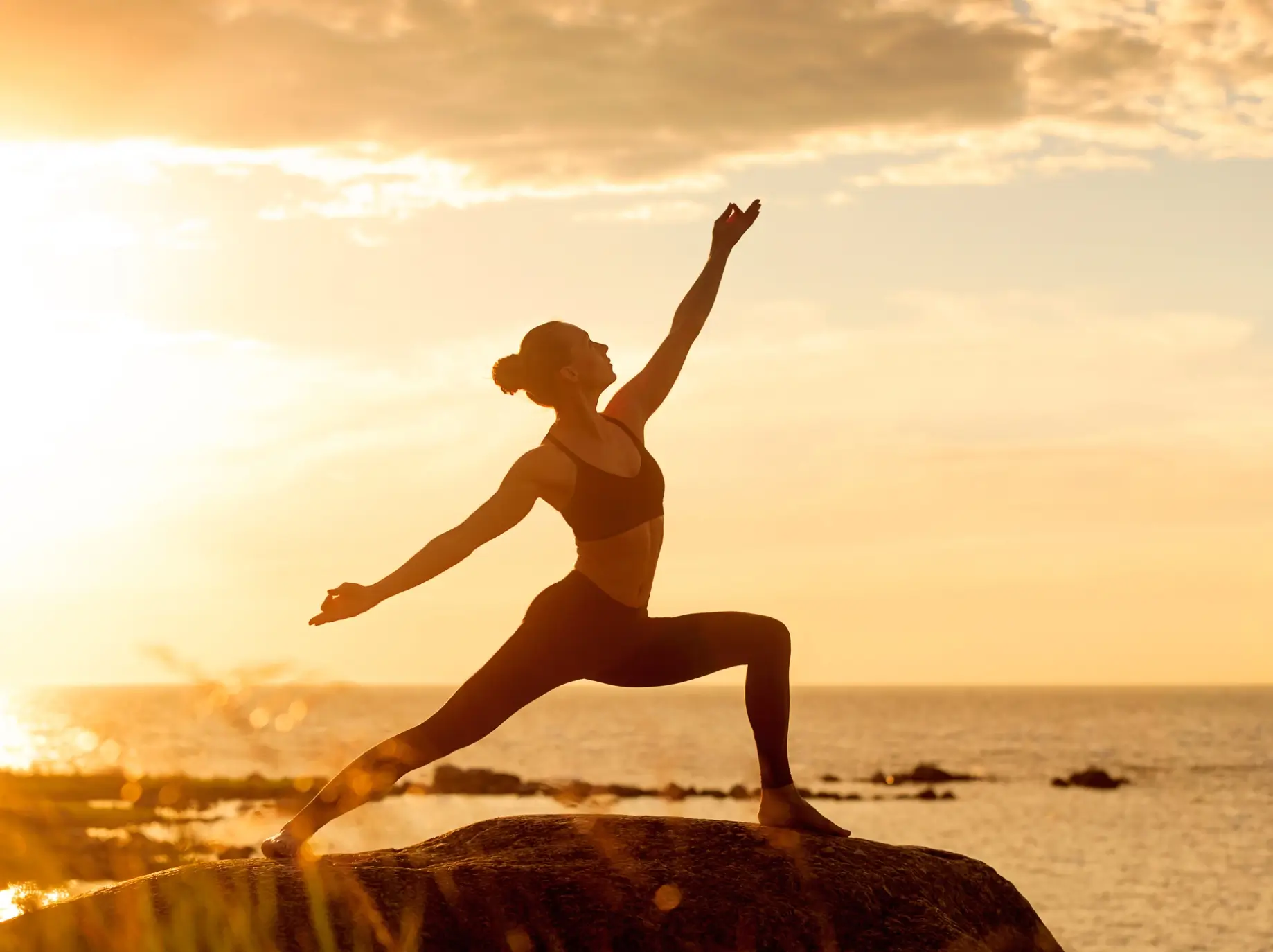 A woman is doing yoga on the beach
