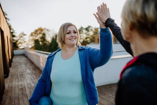 Two people high-fiving outdoors on deck.